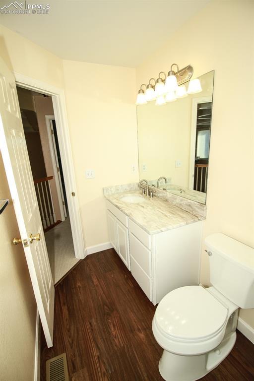 bathroom featuring hardwood / wood-style flooring, vanity, and toilet