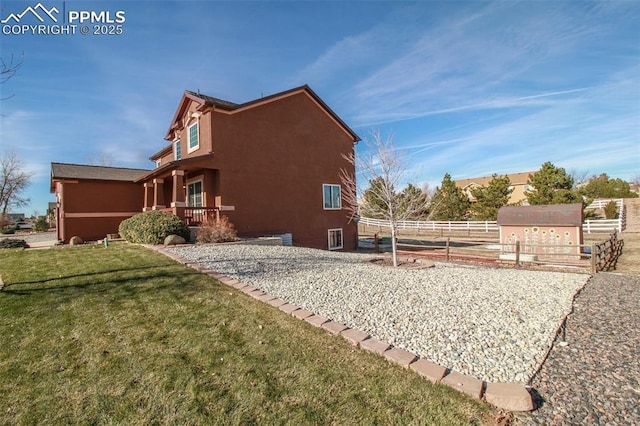 view of home's exterior featuring an outdoor structure and a lawn