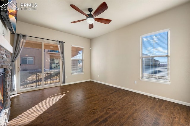 unfurnished living room with ceiling fan, dark wood-type flooring, and a fireplace