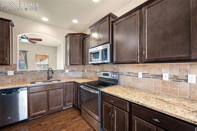 kitchen featuring appliances with stainless steel finishes, dark hardwood / wood-style floors, sink, decorative backsplash, and dark brown cabinets