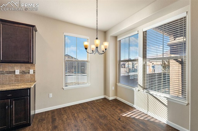 unfurnished dining area with a notable chandelier and dark hardwood / wood-style flooring