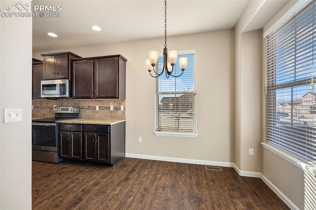 kitchen featuring appliances with stainless steel finishes, backsplash, dark hardwood / wood-style flooring, hanging light fixtures, and dark brown cabinetry