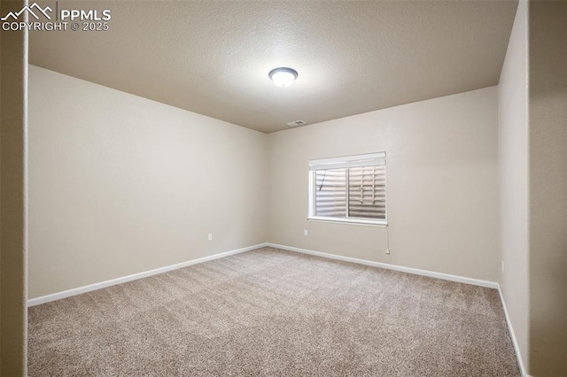 carpeted empty room with a textured ceiling