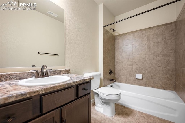 full bathroom featuring tile patterned flooring, tiled shower / bath, vanity, and toilet