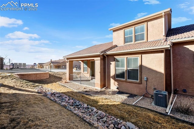 rear view of property with a patio area and central air condition unit