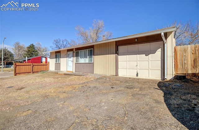 exterior space featuring driveway, a garage, and fence