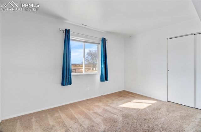 unfurnished bedroom with carpet floors, a closet, and baseboards