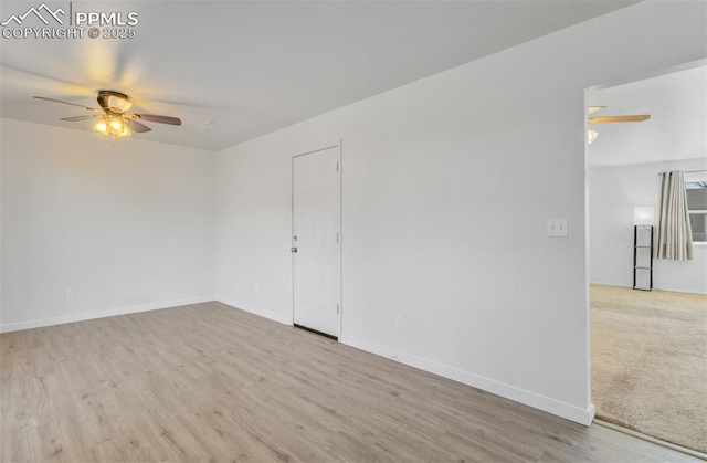 empty room with a ceiling fan, baseboards, and wood finished floors