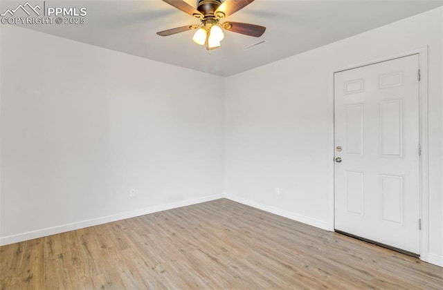 spare room featuring a ceiling fan, baseboards, and wood finished floors