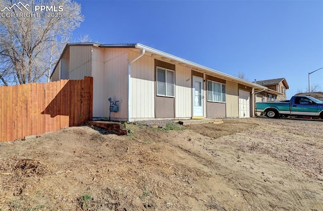 view of front of house featuring an attached garage and fence