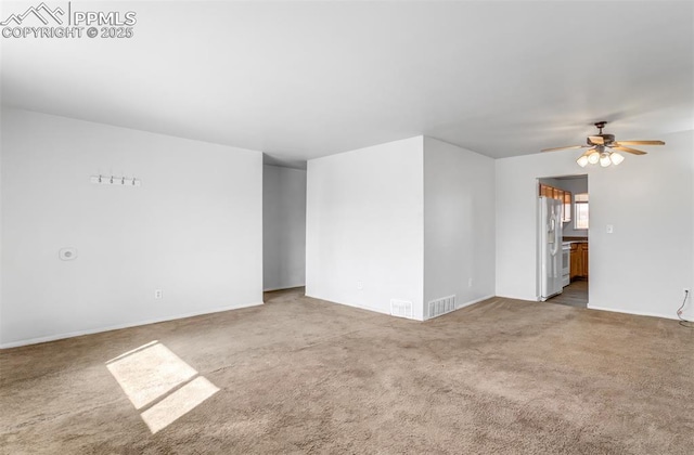 carpeted empty room featuring ceiling fan and visible vents