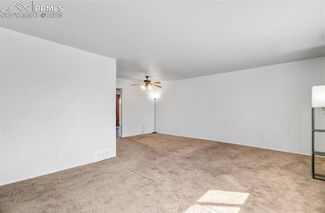 spare room with a ceiling fan, visible vents, and carpet flooring