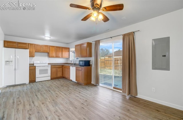 kitchen with white appliances, electric panel, baseboards, light wood-type flooring, and a sink