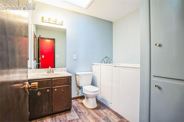 bathroom with vanity, wood-type flooring, and toilet