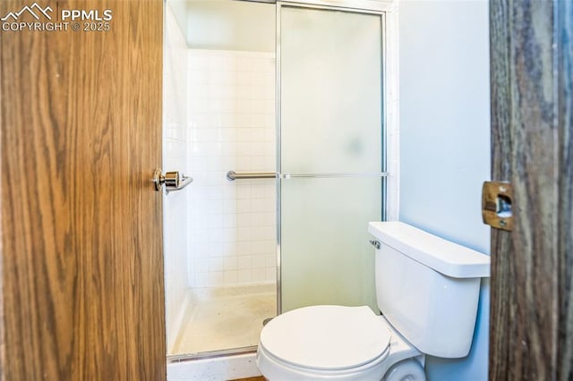 bathroom featuring walk in shower and toilet