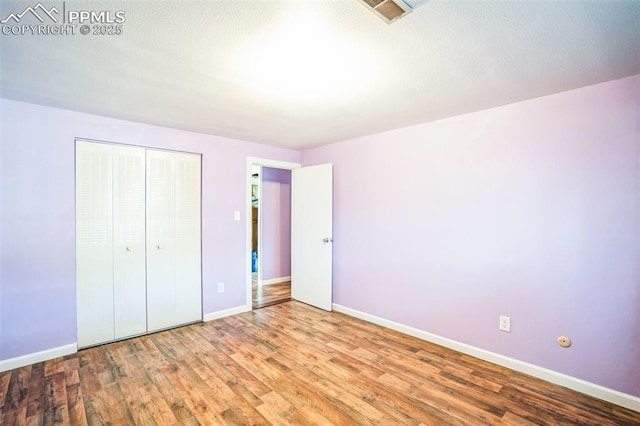 unfurnished bedroom with wood-type flooring and a closet