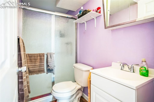 bathroom with vanity, walk in shower, and toilet