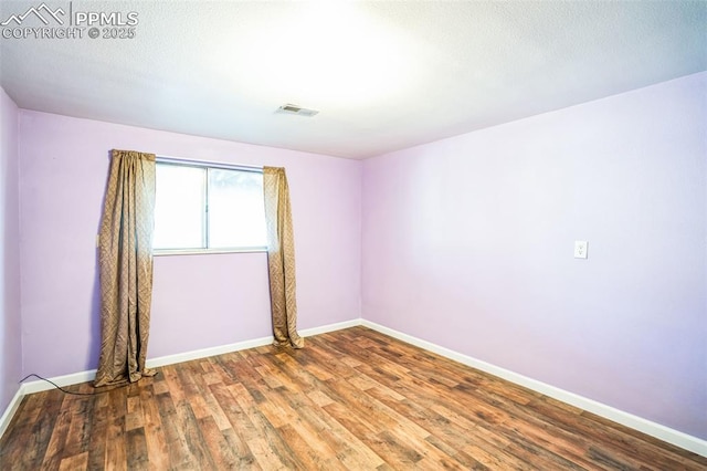 spare room featuring wood-type flooring