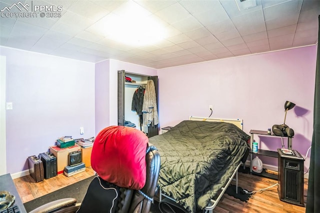 bedroom with wood-type flooring and a closet