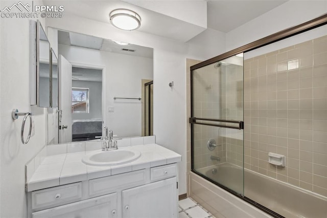 bathroom featuring vanity and shower / bath combination with glass door