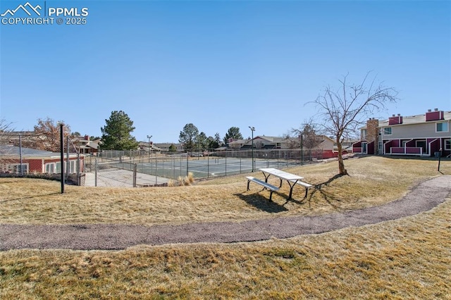 view of home's community with a yard and tennis court