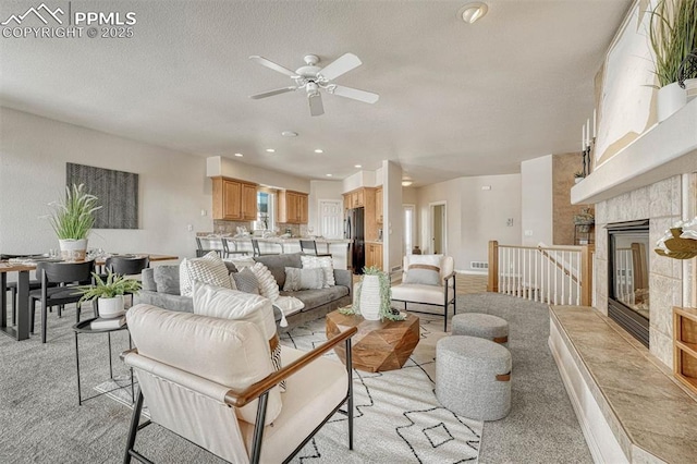 carpeted living room with a textured ceiling and a fireplace