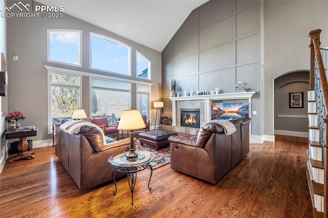 living room with hardwood / wood-style flooring, a fireplace, and high vaulted ceiling