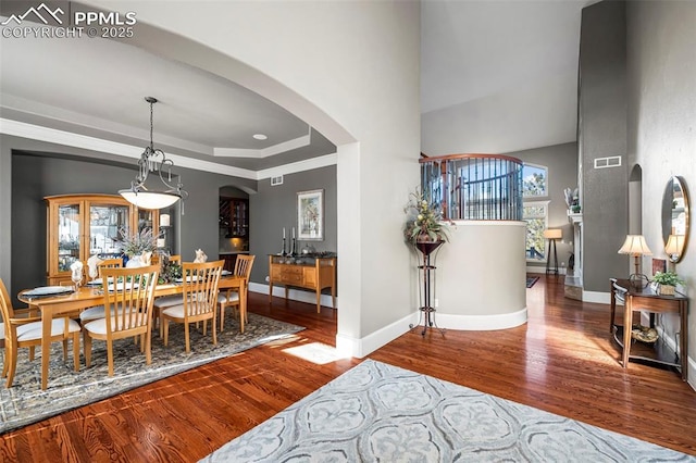 dining area featuring hardwood / wood-style flooring and a raised ceiling