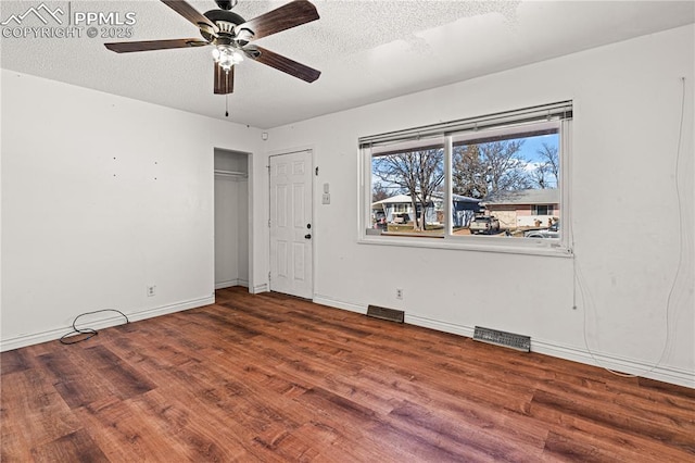 empty room featuring baseboards, visible vents, ceiling fan, wood finished floors, and a textured ceiling