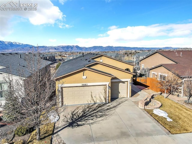 ranch-style home featuring a garage and a mountain view