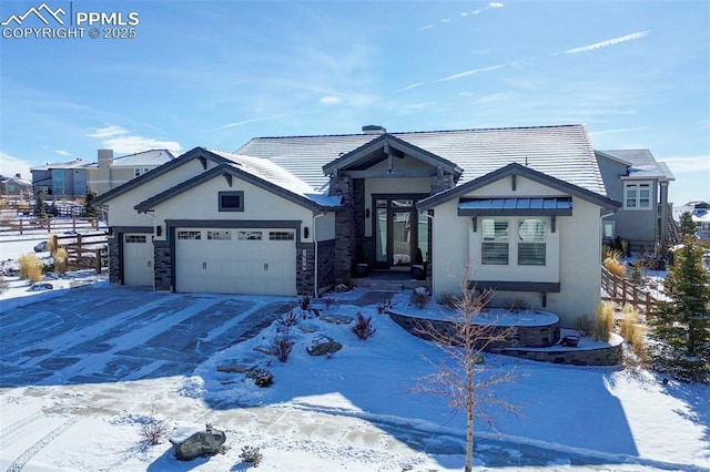 view of front of home with stone siding, an attached garage, and stucco siding