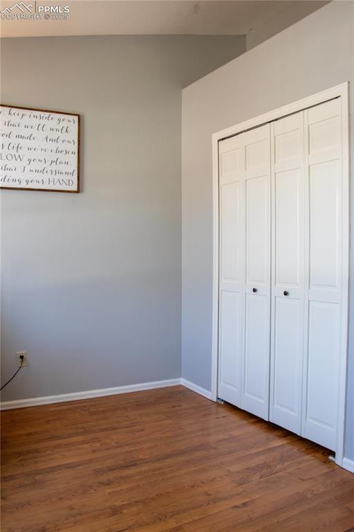 unfurnished bedroom featuring dark hardwood / wood-style flooring and a closet