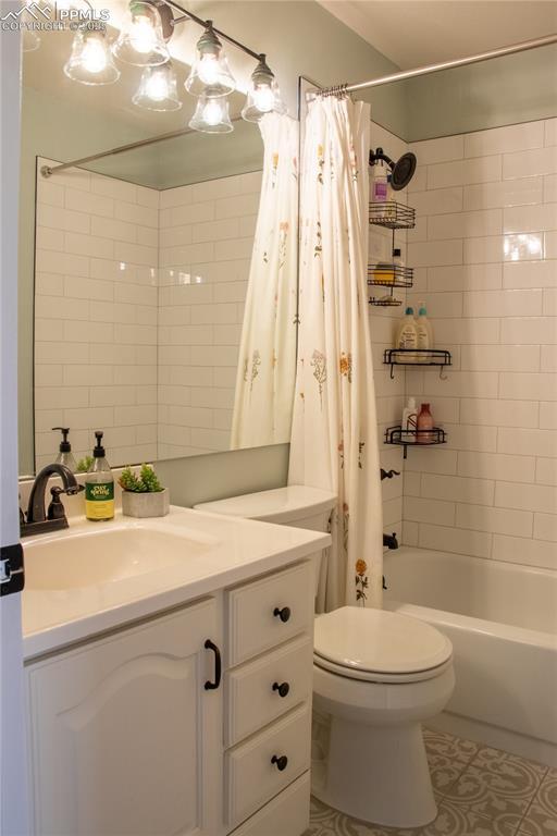 full bathroom featuring shower / tub combo with curtain, vanity, toilet, and tile patterned flooring