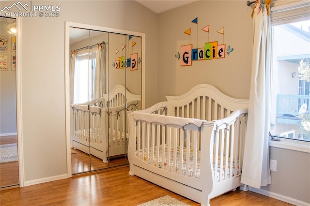 bedroom with a crib and hardwood / wood-style floors