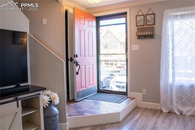 entryway featuring crown molding and light wood-type flooring