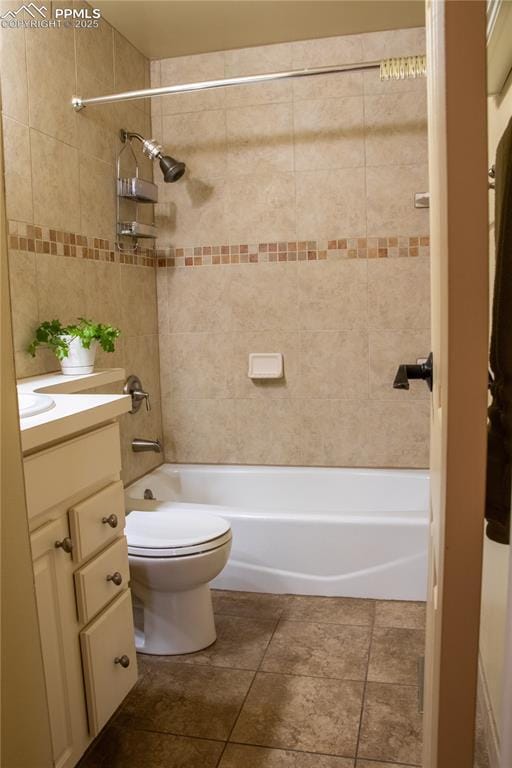 full bathroom featuring vanity, tiled shower / bath, tile patterned flooring, and toilet