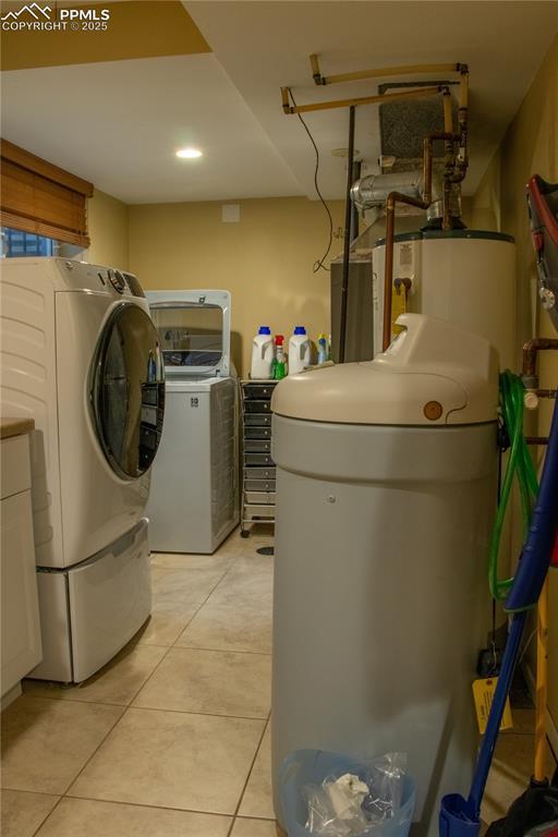 washroom with light tile patterned floors, gas water heater, and independent washer and dryer