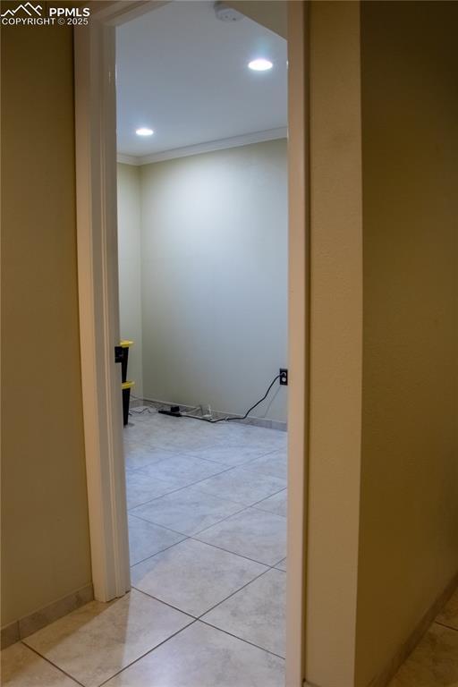 hallway featuring crown molding and light tile patterned flooring