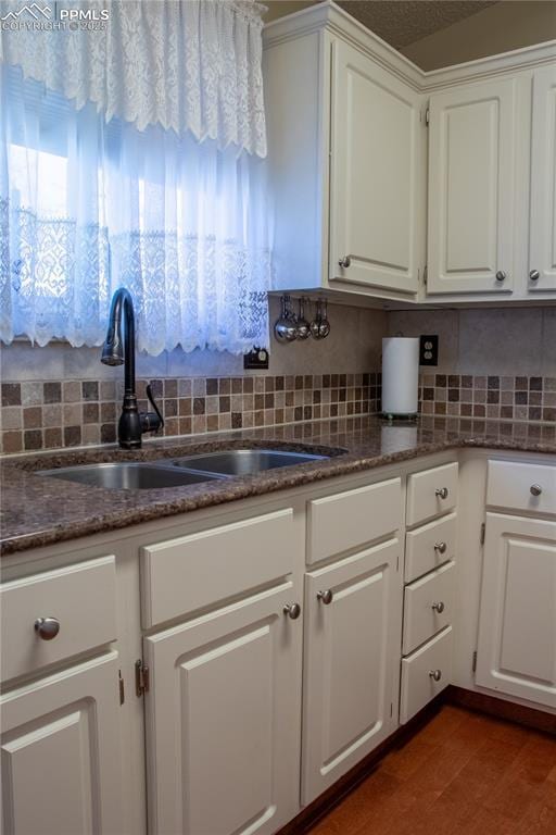 kitchen with sink, white cabinets, and decorative backsplash