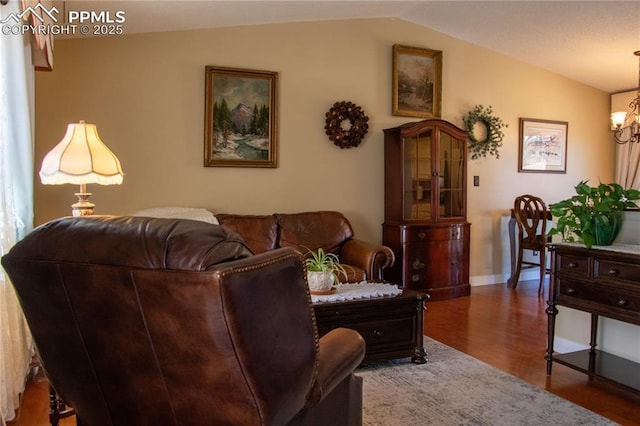 living room with an inviting chandelier, dark wood-type flooring, and vaulted ceiling