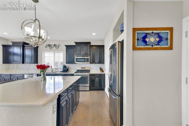 kitchen featuring decorative backsplash, a center island, light wood-type flooring, and stainless steel appliances