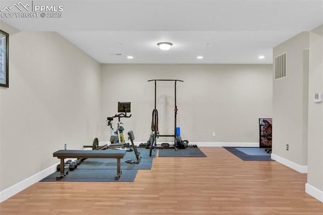 exercise room featuring visible vents, recessed lighting, wood finished floors, and baseboards