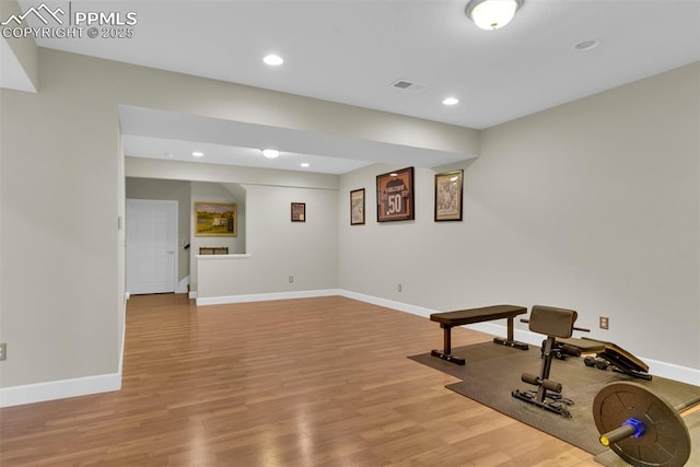 workout room featuring light wood finished floors, recessed lighting, and baseboards