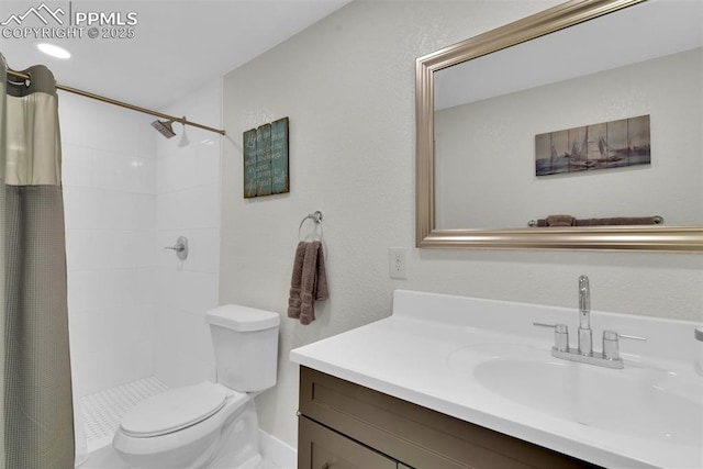 bathroom featuring a tile shower, toilet, and vanity