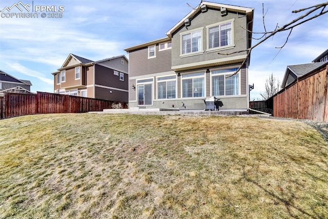 back of property with a yard, fence, and stucco siding