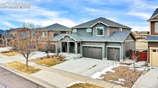 view of front of house featuring stucco siding, fence, roof with shingles, concrete driveway, and a garage