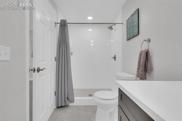 bathroom with vanity, tile patterned floors, toilet, and a stall shower