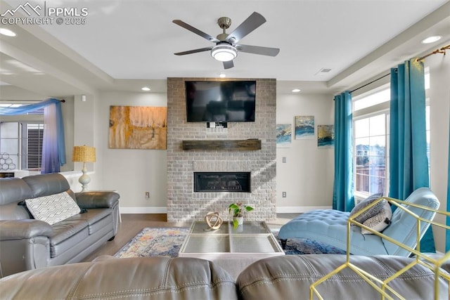 living room featuring recessed lighting, baseboards, a ceiling fan, and a fireplace