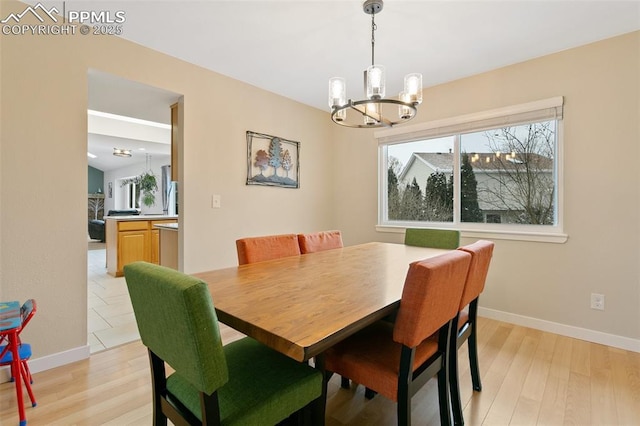 dining area featuring a notable chandelier and light hardwood / wood-style flooring