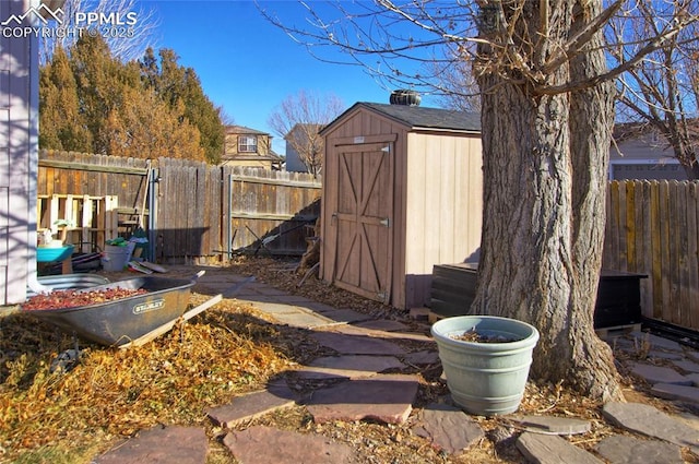 view of yard featuring an outbuilding, a fenced backyard, and a storage unit